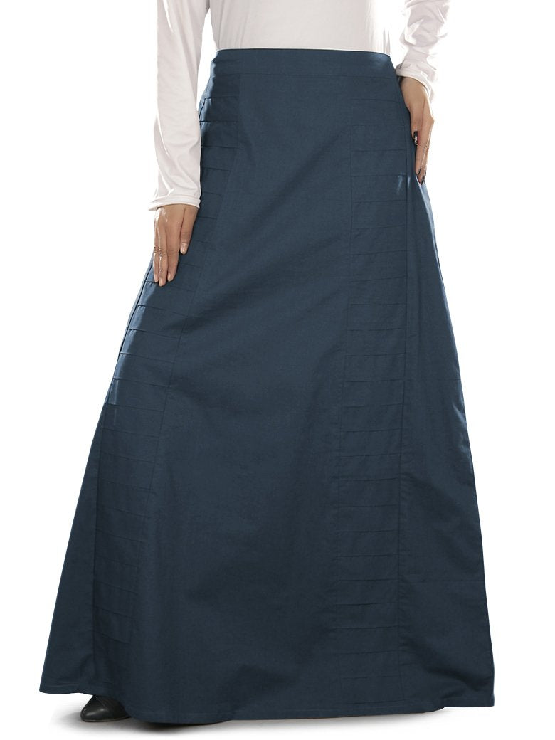A navy blue pleated cotton skirt with elastic waist back and utility pockets on the sides, worn by a person standing against a white background.