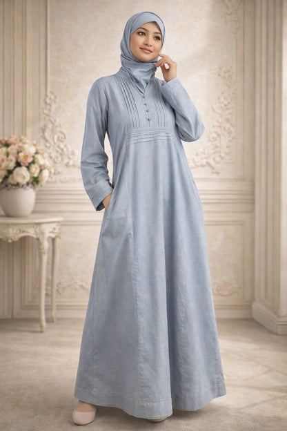 Woman wearing a light blue dress and hijab in an elegant room.