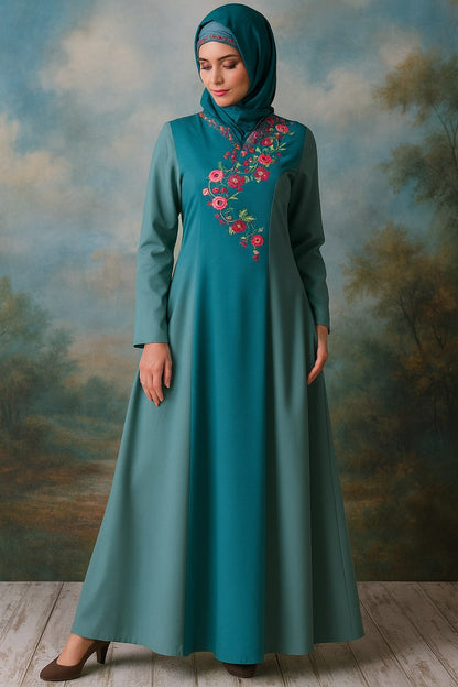 Woman wearing a teal dress with floral embroidery against a scenic background