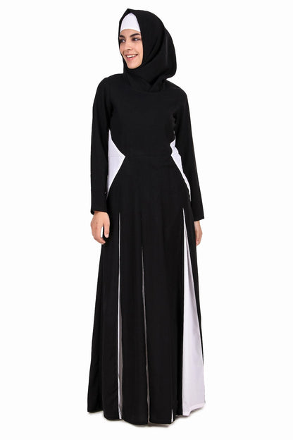 A model wearing a black and white colorblocked Anarkali abaya with contrasting white panels at the waist, round neckline, and sleeves. The abaya is paired with a matching square hijab.