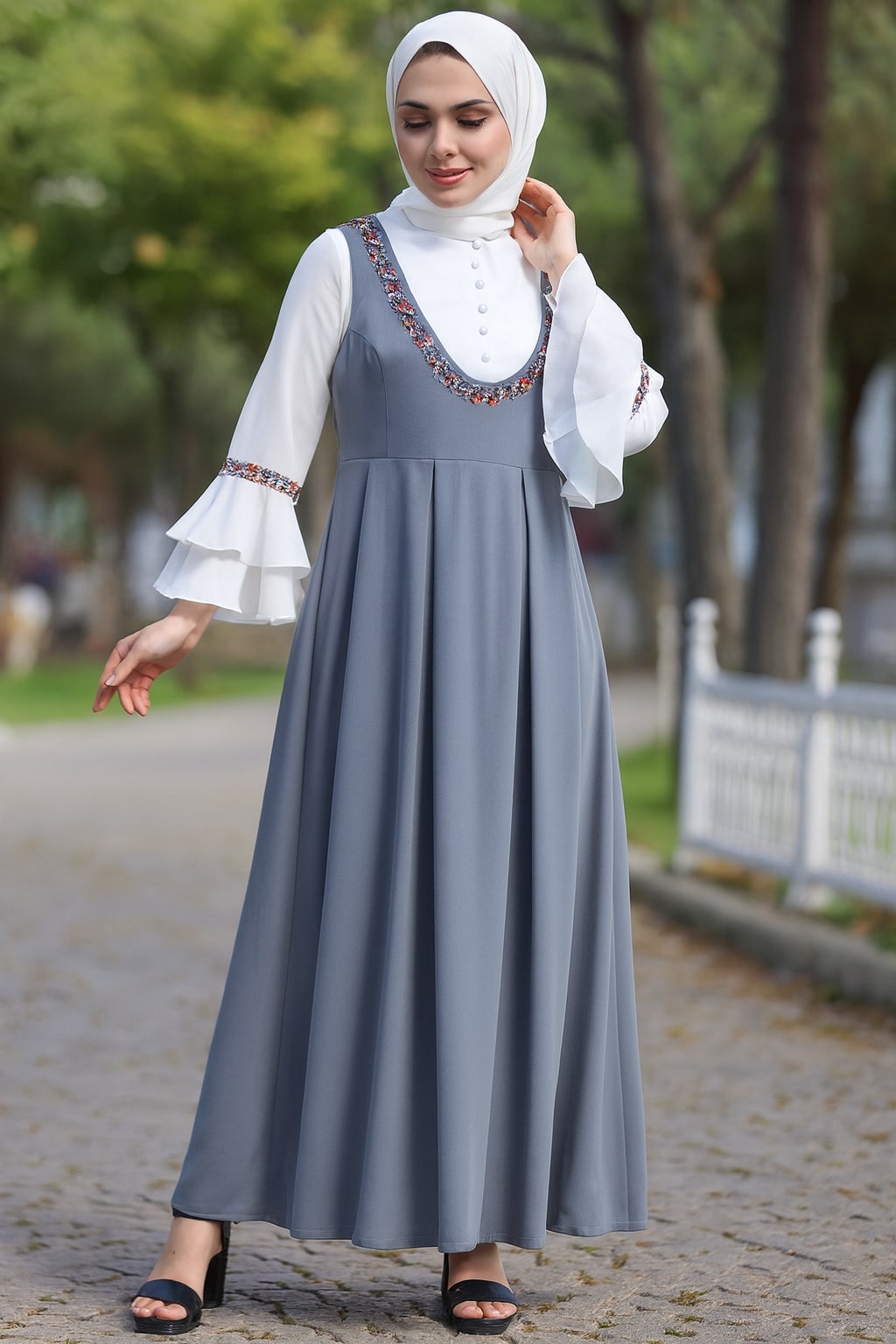 Woman wearing a gray dress with white blouse outdoors