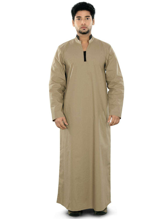 A man wearing a beige ghaniya with a band collar, front open placket, and utility pockets on the sides. The garment appears to be made of a cotton-like fabric.