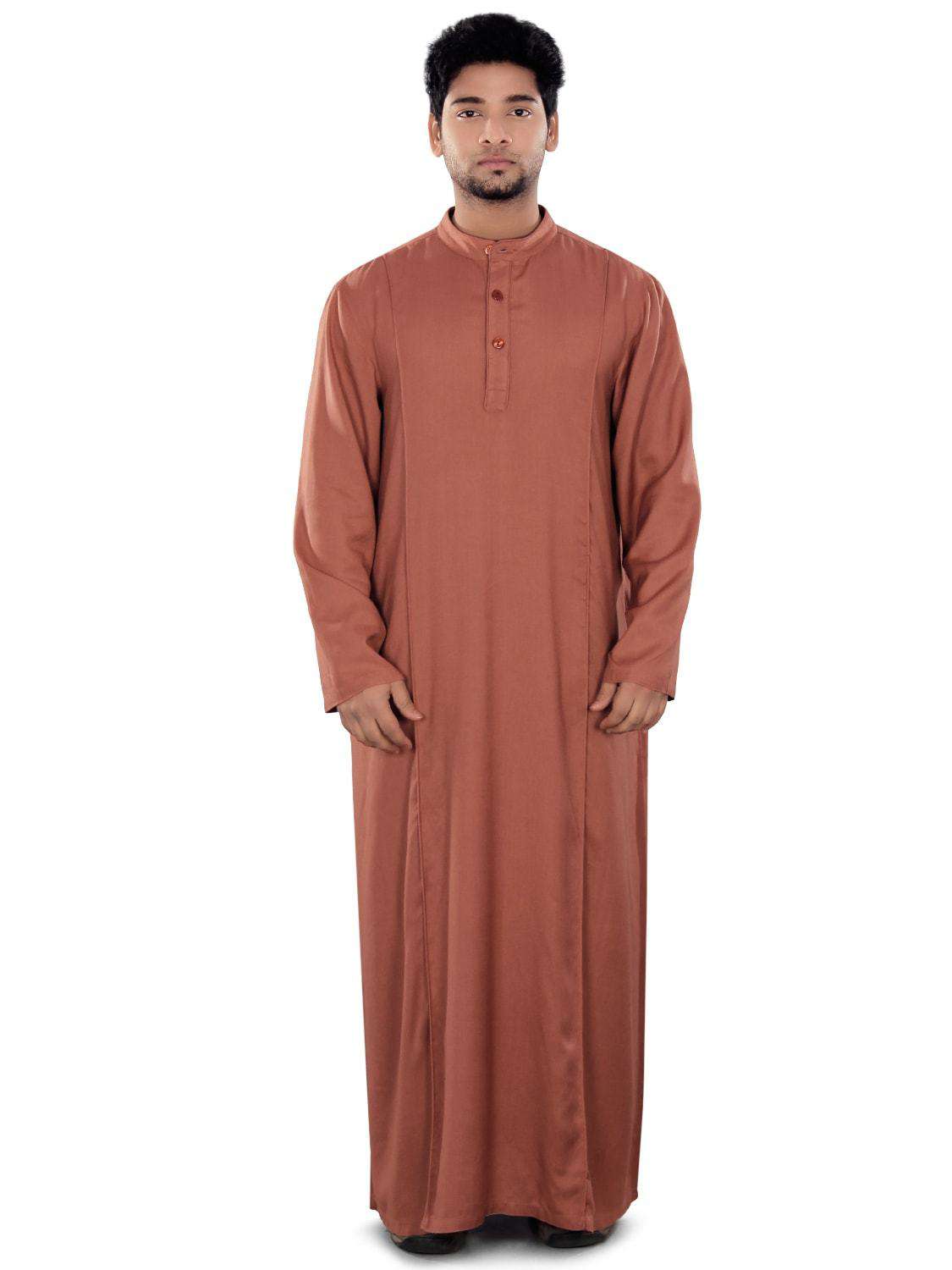 A person wearing a red Maraj Redwood Galabiyya with button closure, side front piping, and utility pockets.