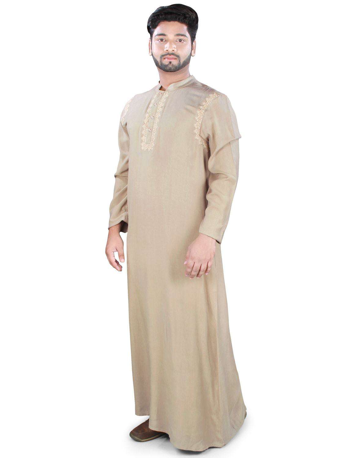 A man wearing a traditional beige Galabiyya with embroidery around the placket and near the armhole, featuring a band collar and straight sleeves.