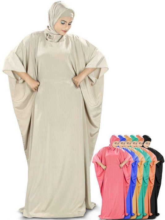 A model wearing a beige Rua Kaftan with adjustable ties at the waist line, also showing a selection of the dress in other colors.