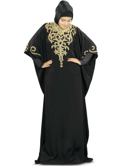 A woman wearing a black Kaftan with hand embroidery work on the neck and sleeves, featuring a band collar neckline and an adjustable belt at waist line.