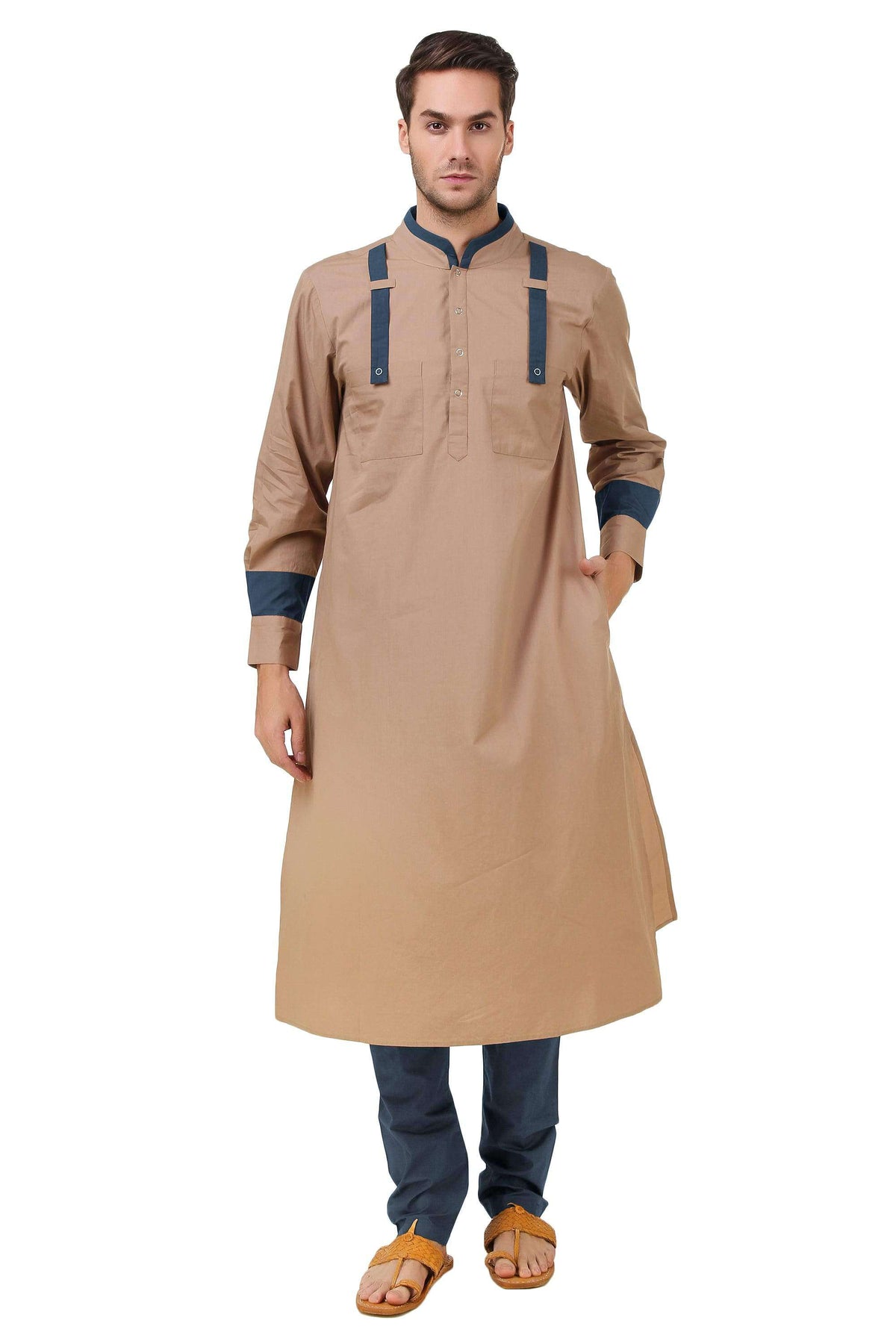 A man wearing a beige kurta pajama with navy blue details and a mandarin collar.